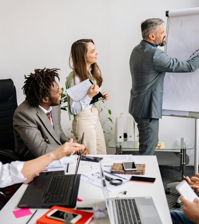 Profissionais de negócios a fazer brainstorming e colaborar em reunião de equipa para projetos de Website numa sala de conferências moderna